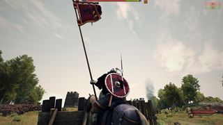 A horseman with the realm's standard raised at the siege camp's palisade